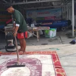 Salah Seorang Pekerja Saat Mencuci Karpet Masjid.