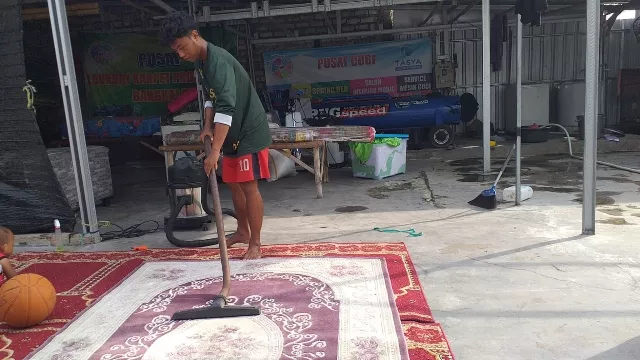 Salah Seorang Pekerja Saat Mencuci Karpet Masjid.