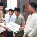 Wakil Bupati Sampang H. Abdullah Hidayat Saat Menyerahkan Bantuan Usai Melaksanakan Tarawih Bersama. (Foto/Prokopim Pemkab Sampang)