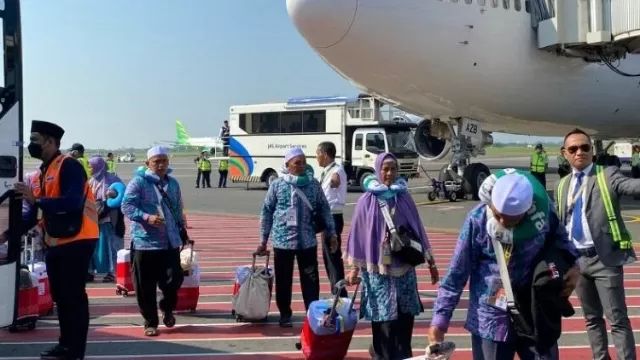 Salah Satu Jemaah Haji Asal Bangkalan Saat Naik Menuju Pesawat Di Bandara Juanda.