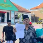 Warga Arosbaya Menunjukkan Bukti Laporan Mantan Kepala Desa Arosbaya Di Kejaksaan Negeri Bangkalan.