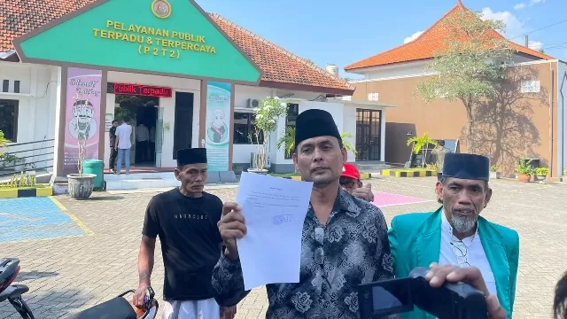 Warga Arosbaya Menunjukkan Bukti Laporan Mantan Kepala Desa Arosbaya Di Kejaksaan Negeri Bangkalan.