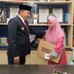 Bupati Sampang H. Slamet Junaidi Saat Memberikan Bantuan Biaya Pendidikan Dan Laptop Kepada Nuktatil Amirah.