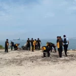Personel Polres Bangkalan Terlihat Membersihkan Sampah Di Pesisir Pantai Pernajuh.
