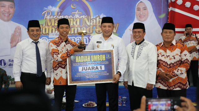Bupati Sampang H. Slamet Junaidi Saat Menyerahkan Hadiah Umroh Gratis. (Foto : Prokopim Pemkab Sampang)