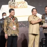 Bupati Sampang H. Slamet Junaidi Saat Menerima Penghargaan Uhc Award. (Foto : Prokopim Pemkab)