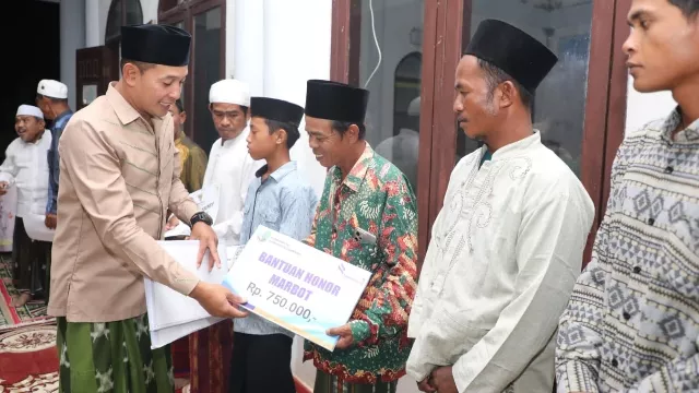 Wakil Bupati Sampang H. Abdullah Hidayat Saat Menyerahkan Bantuan Usai Melaksanakan Tarawih Bersama. (Foto/Prokopim Pemkab Sampang)