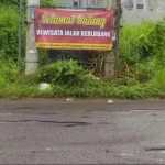 Spanduk Terlihat Dibentangkan Oleh Warga Diikat Di Tiang Listrik.