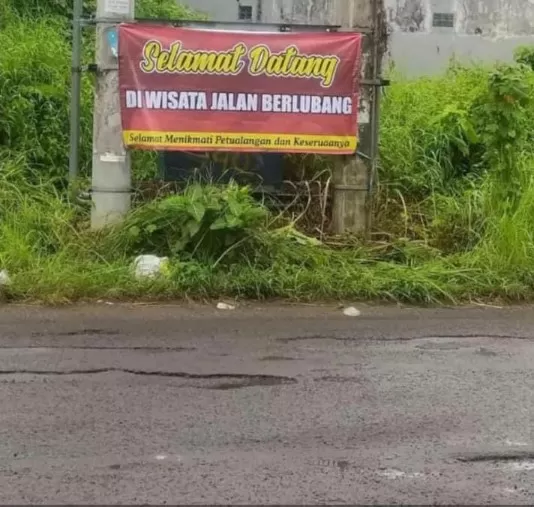 Spanduk Terlihat Dibentangkan Oleh Warga Diikat Di Tiang Listrik.