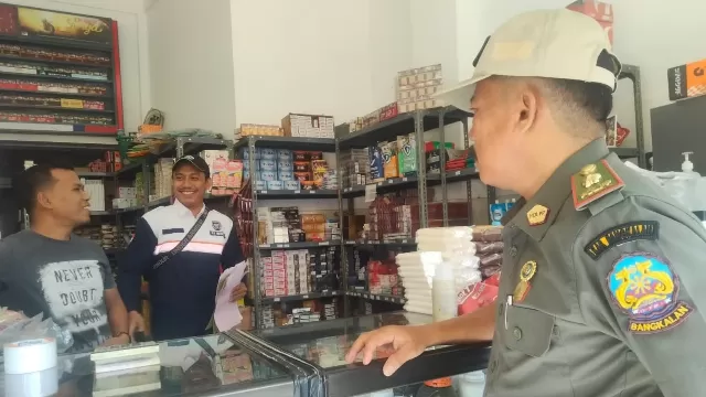 Tim Gabungan Yang Terdiri Dari Satpol Pp, Kejari, Kodim, Subdenpom, Polres Dan Bea Cukai Saat Menyisir Salah Satu Pasar Di Bangkalan.