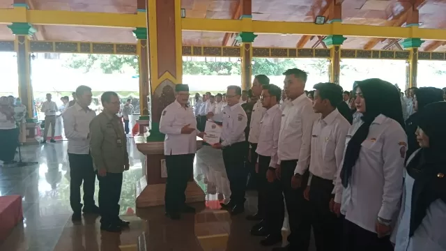 Plt Bupati Bangkalan, Drs. Mohni Secara Simbolis Menyerahkan Sk Pppk Kepada Salah Satu Pegawai.