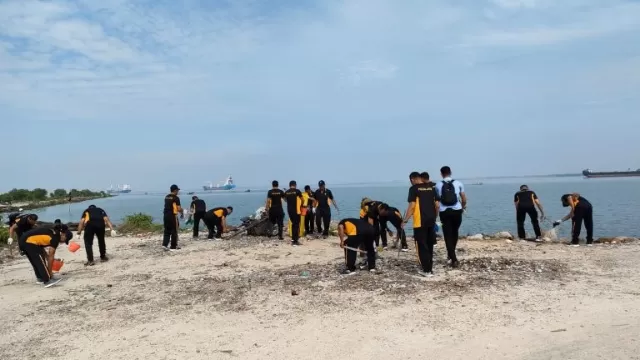 Personel Polres Bangkalan Terlihat Membersihkan Sampah Di Pesisir Pantai Pernajuh.