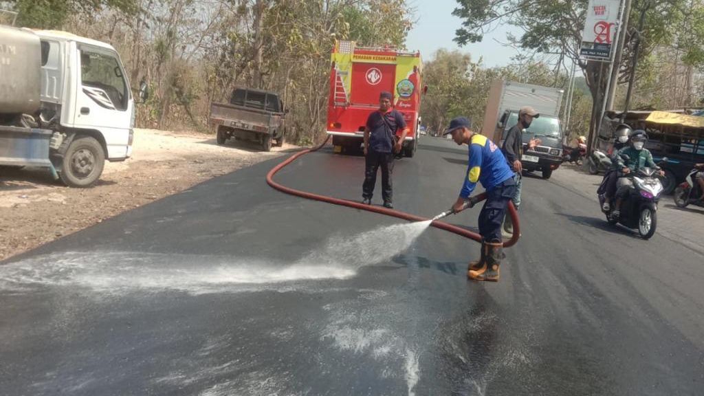 Petugas Damkar Saat Melakukan Penyemprotan Jalan Yang Licin