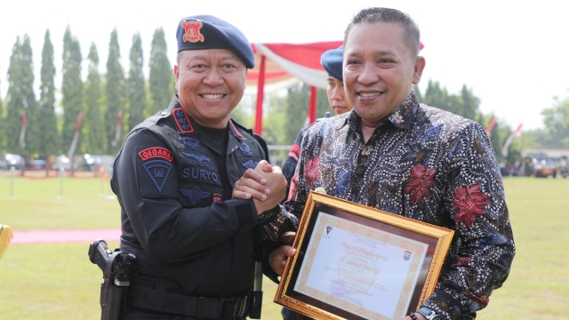 Bupati Sampang H. Slamet Junaidi Saat Menerima Penghargaan Dari Dansat Brimob Polda Jatim. (Foto : Prokopim Pemkab)