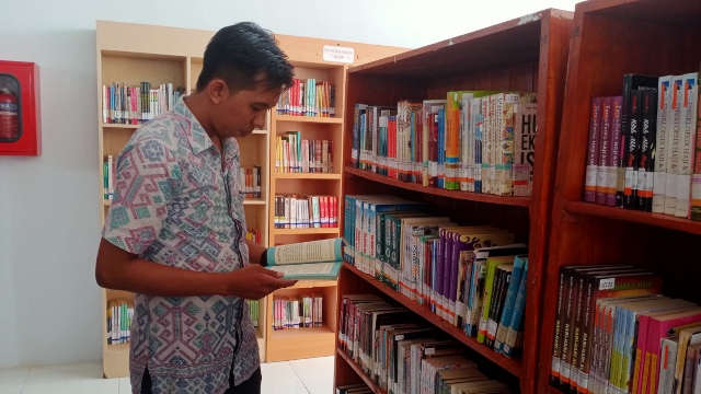 Salah Satu Pengunjung Saat Memilih Buku Refrensi.