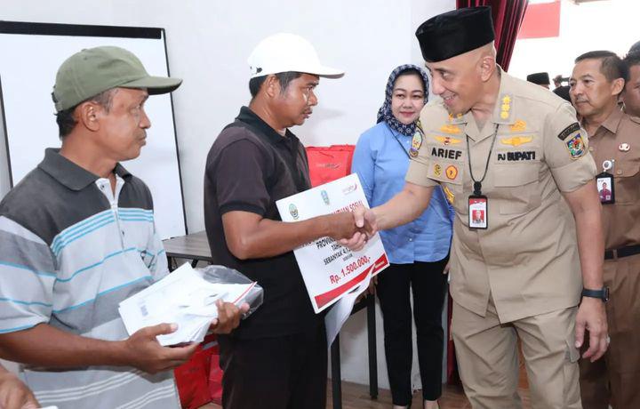 Pj Bupati Bangkalan Saat Menyerahkan Bantuan Kepada Warga.