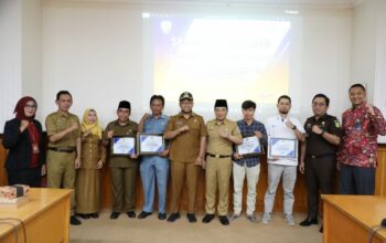 Wakil Bupati Sampang H. Ahmad Mhfudz saat memberikan penghargaan kepada kepala desa dengan capaian target 100%