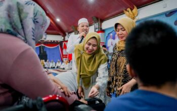 Caption: Bupati Sampang H. Slamet Junaidi didampingi Ketua TP PKK Kabupaten Sampang Evi Slamet Junaidi saat menyantuni anak yatim dan menyalurkan bantuan bagi penyandang disabilitas