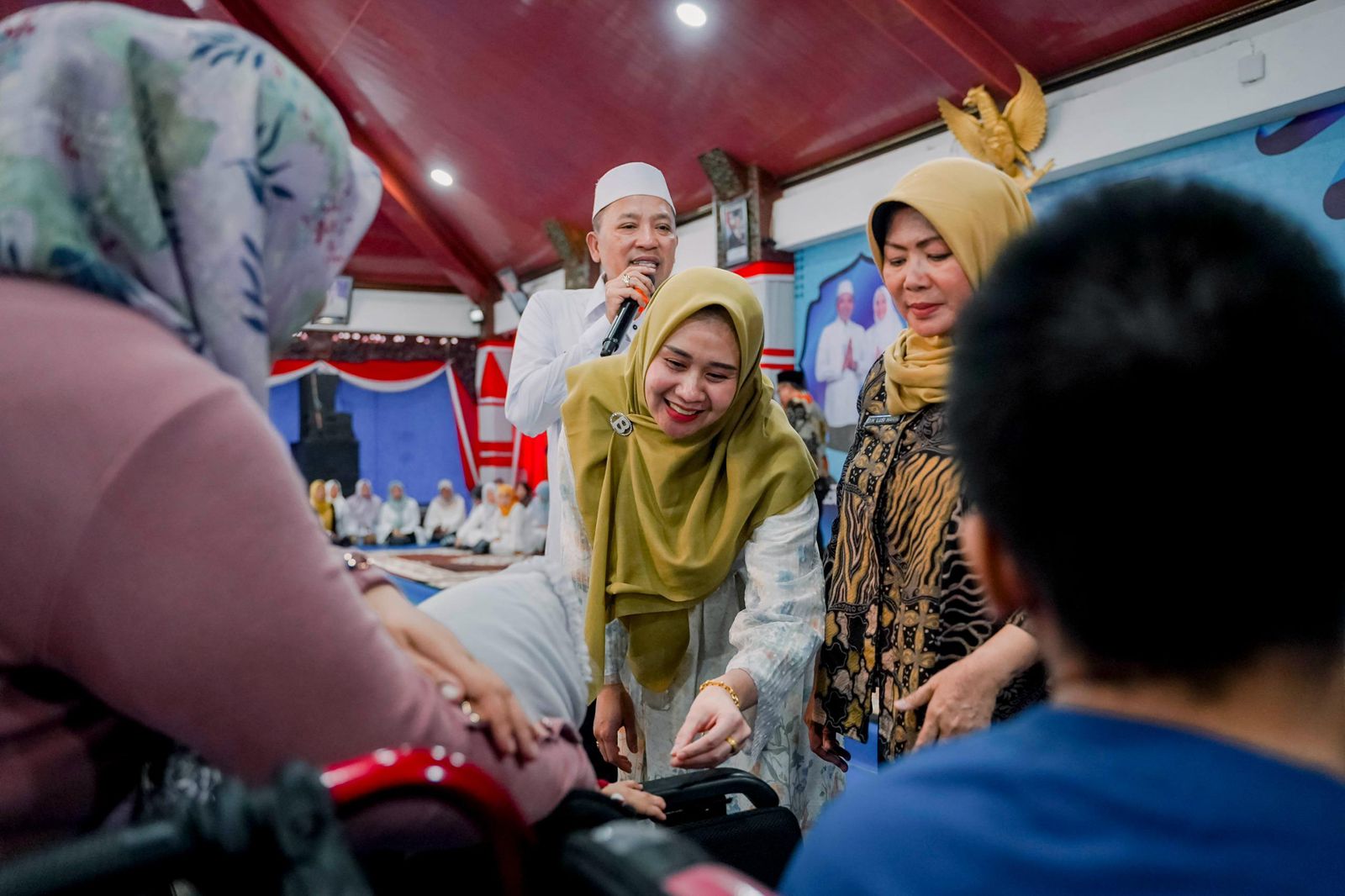 Caption: Bupati Sampang H. Slamet Junaidi didampingi Ketua TP PKK Kabupaten Sampang Evi Slamet Junaidi saat menyantuni anak yatim dan menyalurkan bantuan bagi penyandang disabilitas